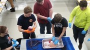 Stop the Bleed Training - Students using gauze with fake blood being pushed through to simulate the process.